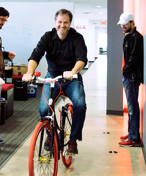 Calvin Carter testing out a new bike in the office. Photo courtesy Bottle Rocket.