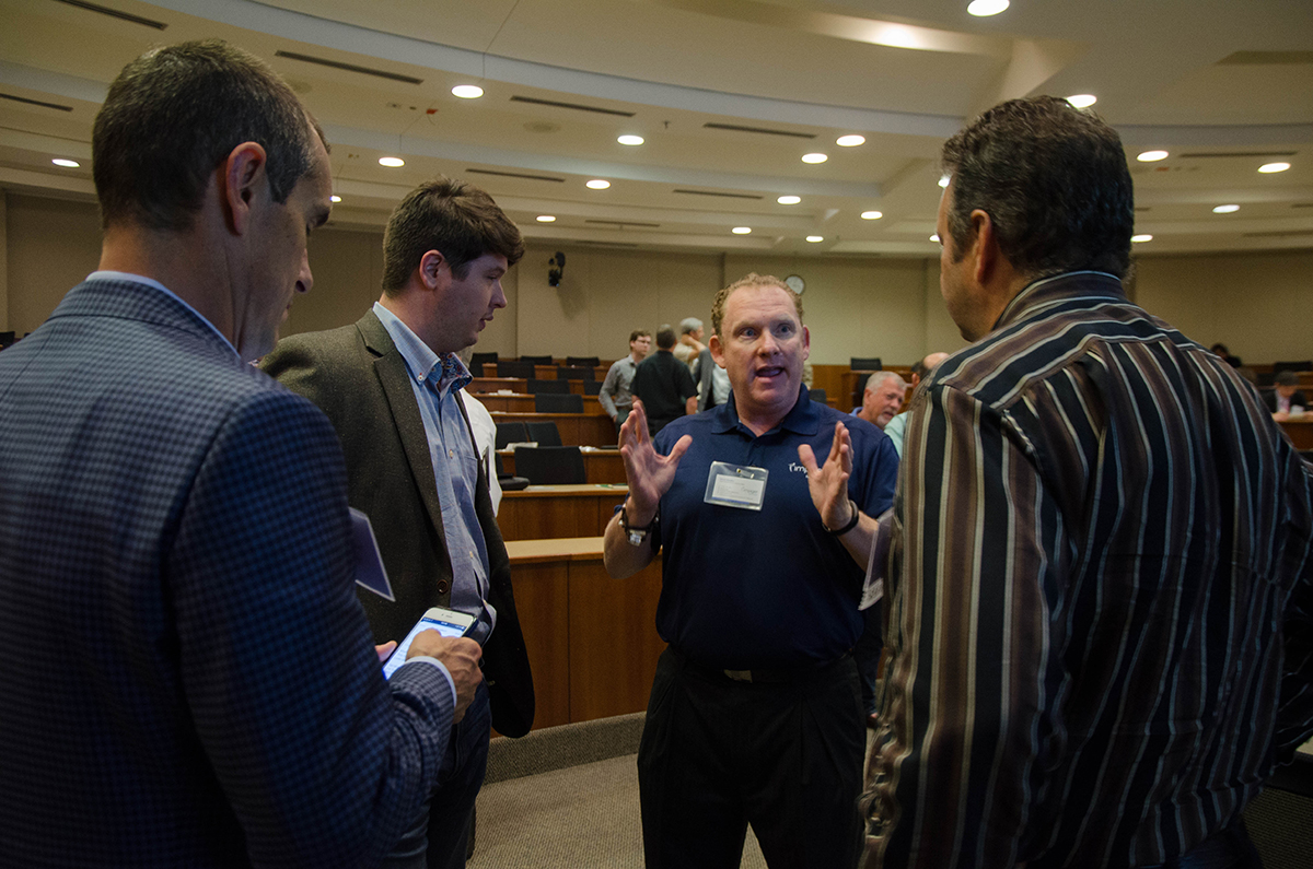 Tad Molntosh (middle) talks business with Moderator Bob Gessel (right) during networking hour at Tech Titans. Photo by Hannah Ridings.