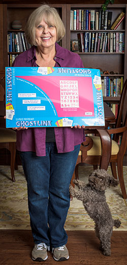 Mary Russell Sarao holds a package of Ghostline poster board. Photo by Michael Samples.