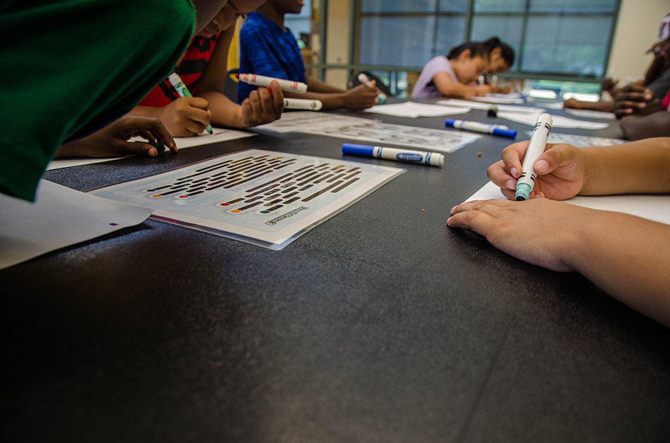 Children color patterns on pieces of paper at during a Perot Tech Truck science lesson. [ Photo by Hannah Ridings ]