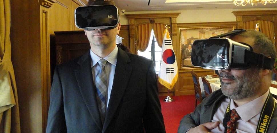 Executive MBA students Dustin West (left) and Ramneek Bali, with Ericsson, use virtual reality goggles in a banquet room at the Bank of Korea to “watch an event” held years ago in the same room.