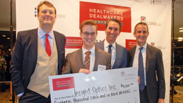 Aaron Enton of Insight Optics holds the winner's check at the Health Wildcatters Pitch