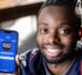 SMU student-entrepreneur Trevor Gicheru, smiling, and posing next to the study app he created.