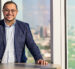 IMAGE: CurveBiosciences founder, Ritish Patnaik, standing at a table with the Dallas skyline behind him.