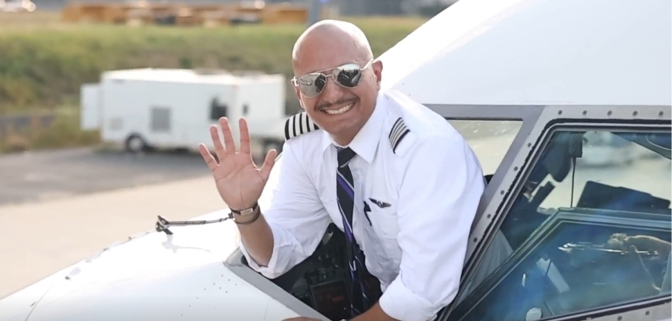 pilot waving from cockpit window